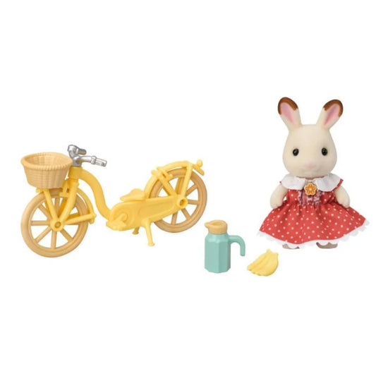Set giocattolo Epoch Sylvanian Families con ragazza coniglio cioccolato in bicicletta, dettagli colorati e scene di gioco.